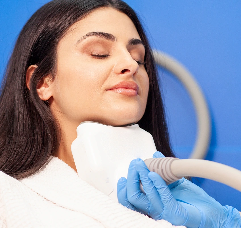Woman receiving ultrasound facial treatment with handheld device on neck
