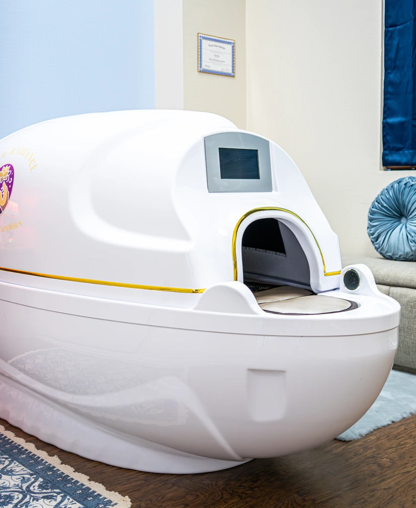 White cryotherapy chamber with yellow accents in wellness clinic treatment room