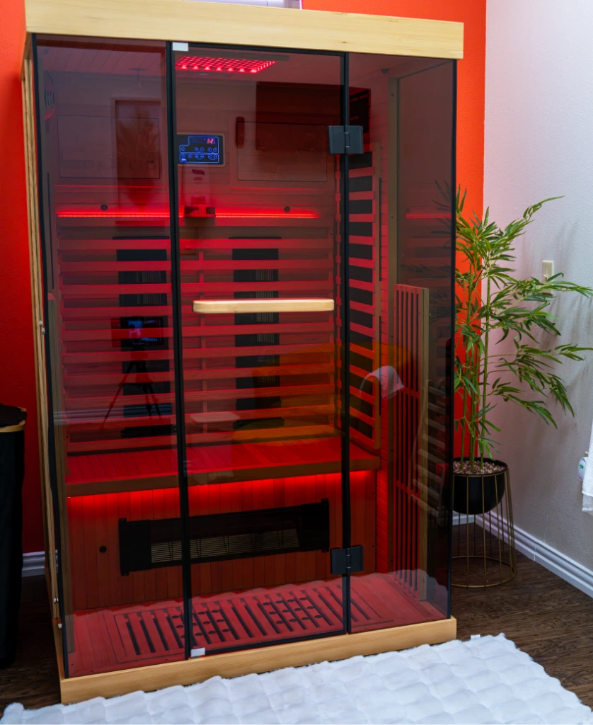 Red light therapy sauna cabin with glowing red LED panels and control display