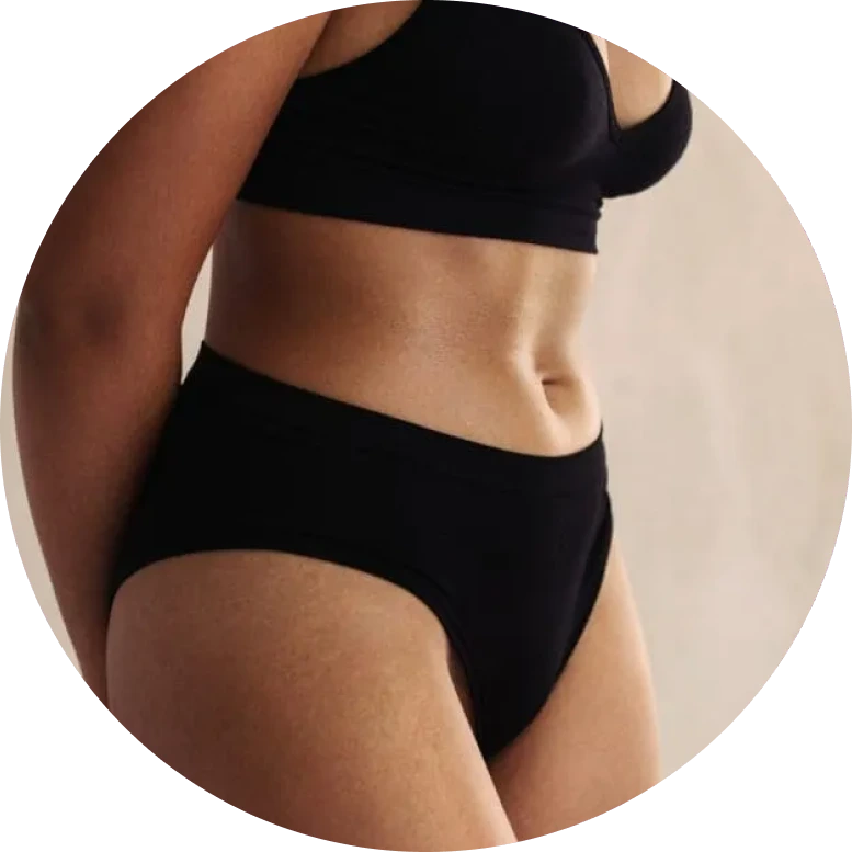Person in black sports bra and briefs showing toned midsection and torso