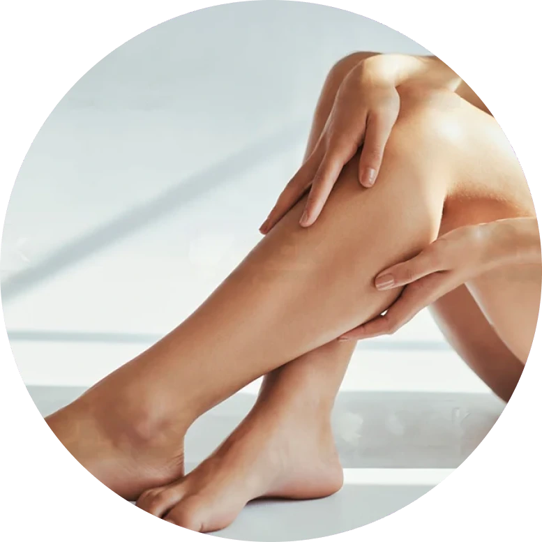 Person's hands massaging their own leg and calf against a light background