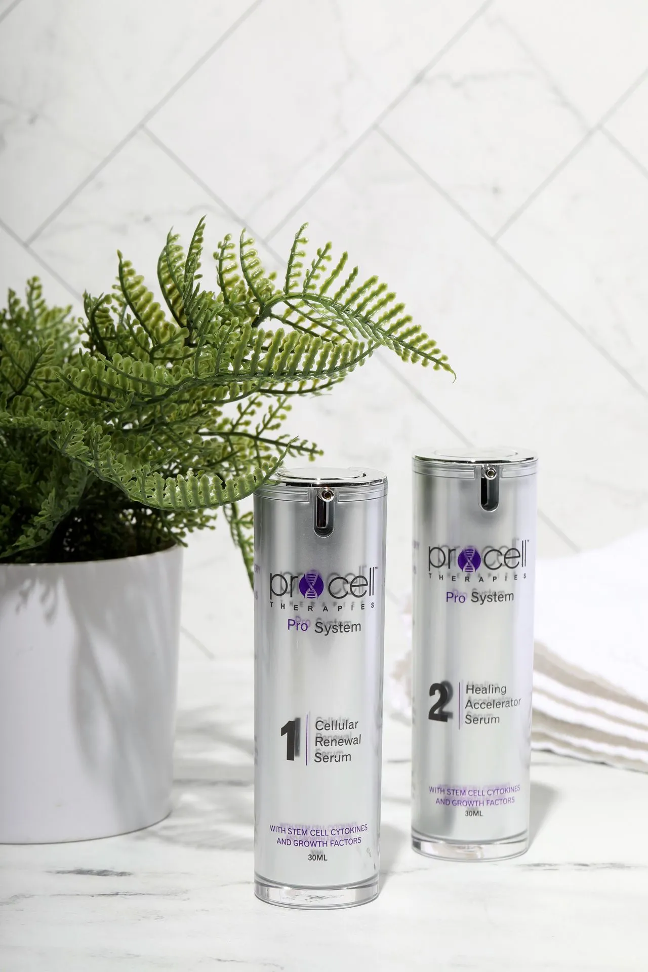 Procell Therapies Pro System two-step serum bottles next to potted fern plant on marble surface