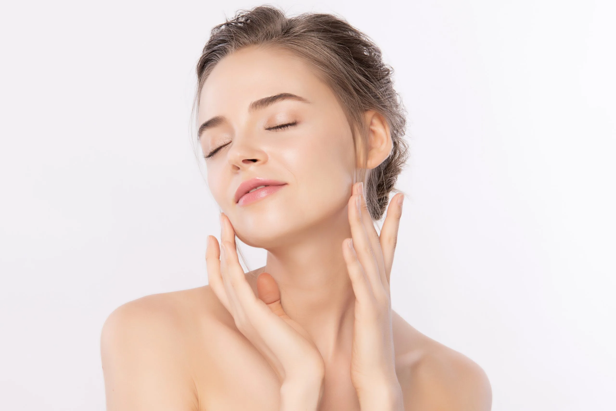 Woman with eyes closed touching her face with both hands